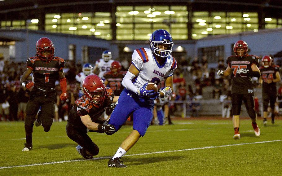 Ramstein wide receiver Eric Manuel strolls into the end zone after catching a pass from quarterback Caden Nims during the second quarter of the Royals' mathup with Kaiserslautern on Sept. 15, 2023, at Babers Stadium in Kaiserslautern, Germany. Diving at his legs is Raider safety Logan Bell.