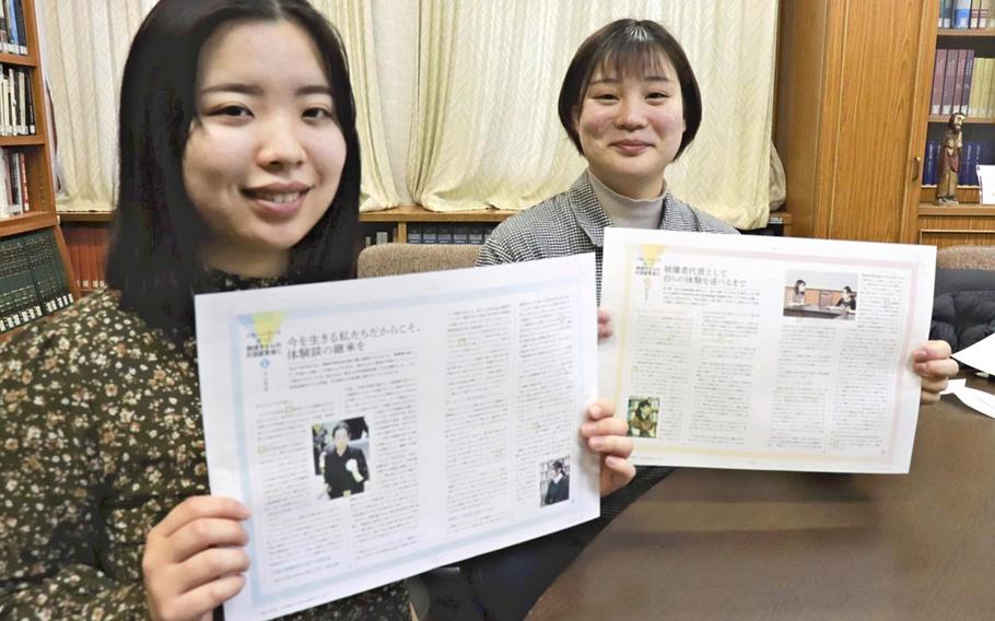 Misato Kaji, right, and Hanae Hirayama seen in in Nagasaki City, Japan, on Jan. 11, 2022, show pages from their pamphlet featuring A-bomb survivor Nobuko Oka .