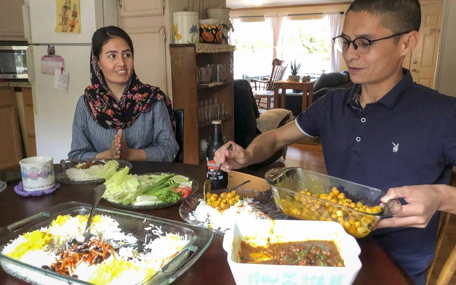 Mohammed Naiem Asadi helps himself to some chickpeas cooked by his wife, Rahima, at their home in the suburbs of Atlantic City, N.J., Oct. 26, 2021.