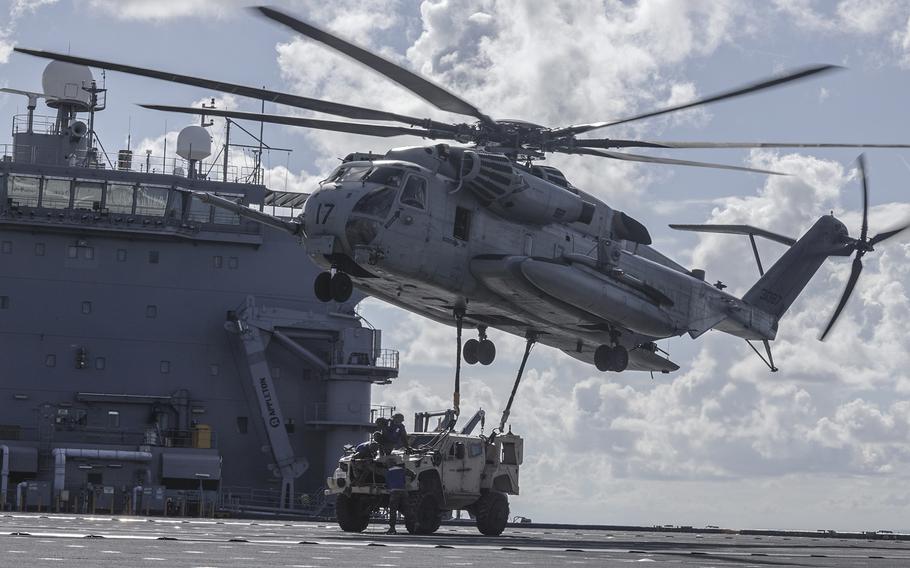 A CH-53E Super Stallion from Marine Medium Tiltrotor Squadron 262 picks up a joint light tactical vehicle from the USS Miguel Keith somewhere in the Philippine Sea, Aug. 8, 2022.