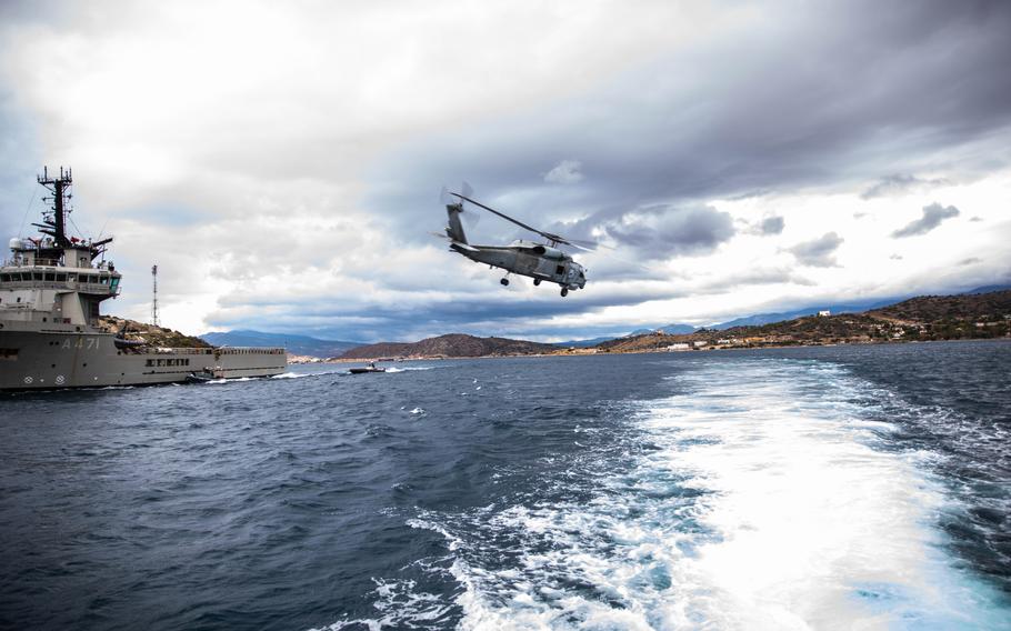 A Greek UH-1H Huey provides security during a training drill Nov. 24, 2021, with Navy SEALs and Army Green Berets in Athens. The U.S. recently donated Mark V special operations boats to Greek forces. 