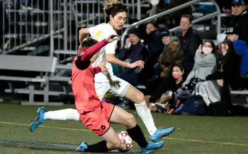 Nile C. Kinnick's Bennett Schmid and Yokota's Senna Solberg battle for the ball during Friday's DODEA-Japan soccer match. The Red Devils won 3-0.
