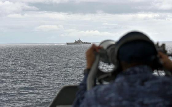 A sailor aboard the Japan Maritime Self-Defense Force destroyer JS Kirisame a monitors the littoral combat ship USS Oakland during an exercise near the Solomon Islands, Monday, Aug. 8, 2022.