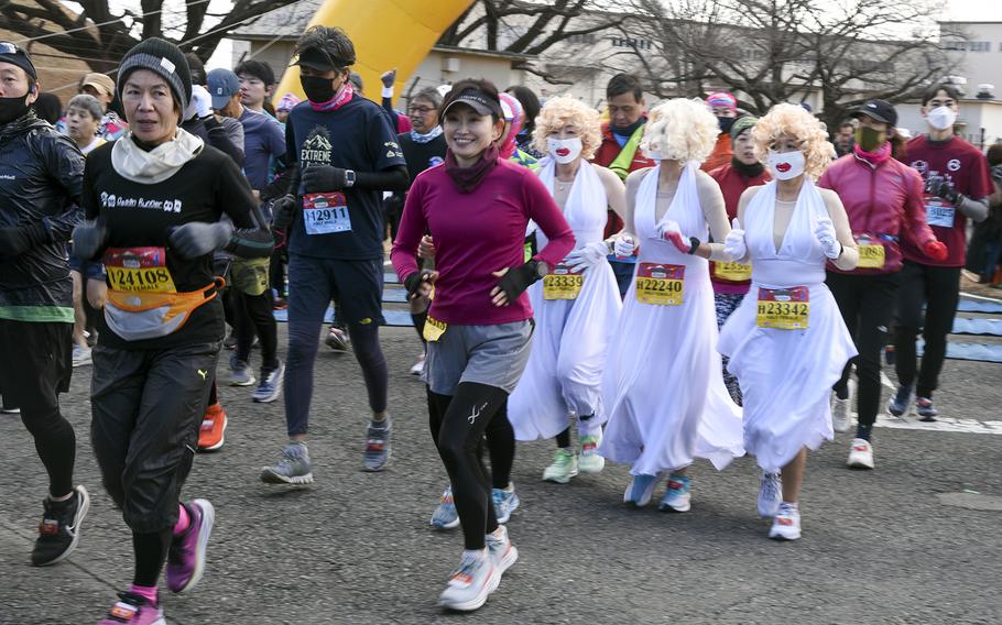 Runners, including some in costumer, participate in a half-marathon during the 42nd annual Yokota Striders Frostbite Road Race at Yokota Air Base, Japan, Sunday, Jan. 22, 2023.