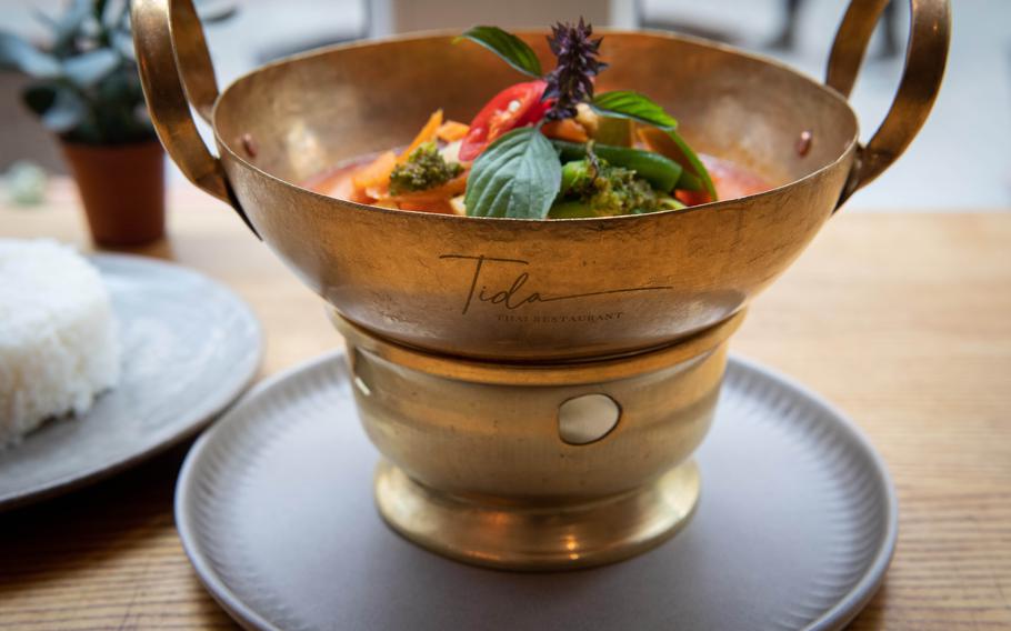 The vegetable panang curry at Tida Thai Restaurant is served in a metal pot with the restaurant’s name on it. 