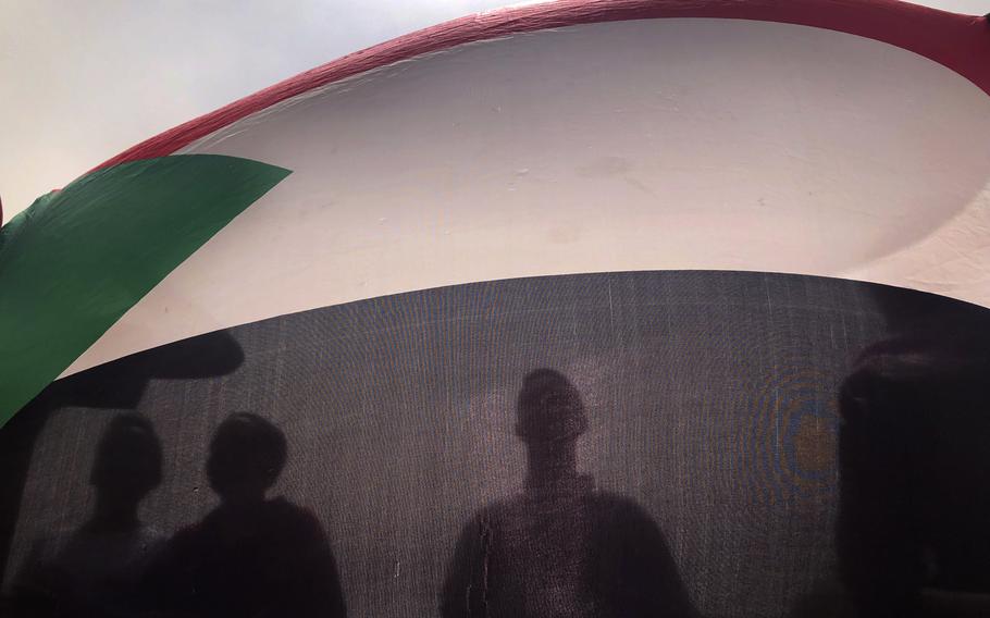 Sudanese protesters hold their national flag as they march during a demonstration against the ruling military council, in Khartoum, Sudan. June 30, 2019. According to reports on Thursday, Feb. 10, 2022, at least 54 children have died  at a government-run orphanage in Khartoum, in the past three months.