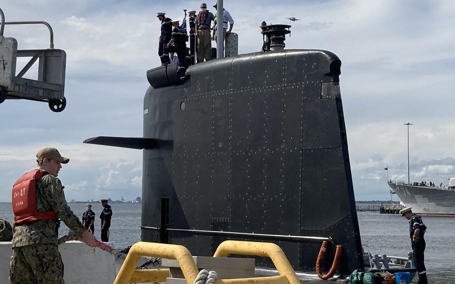 A U.S. Navy sailor helps the French submarine Améthyste moor at Naval Station Norfolk on Sept. 16 2021.