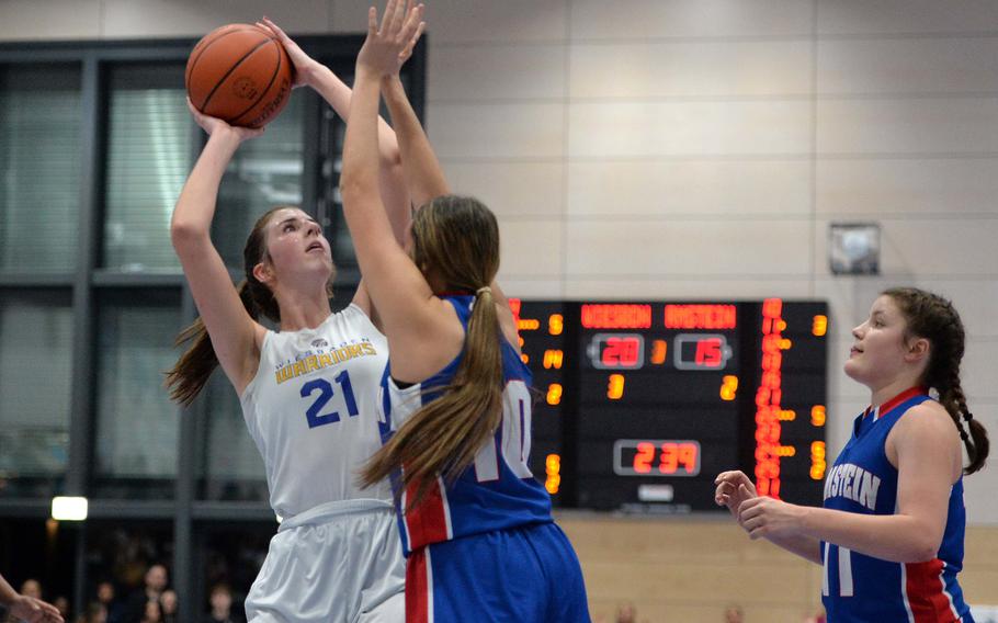 Wiesbadens Lyndsey Urick shoots over Ramsteins Rachel Sorenson in the Division I championship game at the DODEA-Europe basketball championships in Ramstein, Germany, Feb. 18, 2023. The Warriors beat the Royals 43-34 to take the title. Al right is Katya von Eicken.