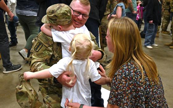 From left, Staff Sgt. Larry Davis reunites with his children, Parker and Camryn, and wife, Samantha, during a 3-197th Field Artillery Regiment welcome home ceremony Feb. 8 at the Manchester armory. About 370 soldiers, including a battery of 84 guardsmen from Michigan, deployed last spring to the Middle East. The New Hampshire Army National Guard HIMARS (high mobility rocket system) battalion completed a nine-month rotation in support of Operations Spartan Shield and Inherent Resolve. Photo by Master Sgt. Ch