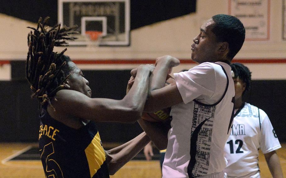 Gimme that ball! Zama's Derek Smith and Robert D. Edgren's JeShawn Spaights-Pace tussle for the ball during Friday's DODEA-Japan boys basketball game. The Trojans won 61-37.