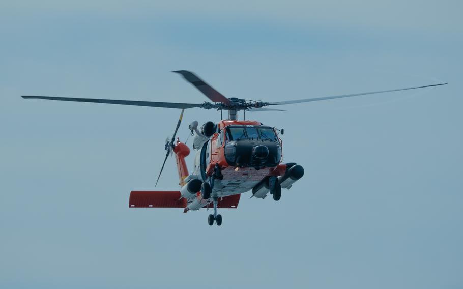 A helicopter flies into a blue sky.