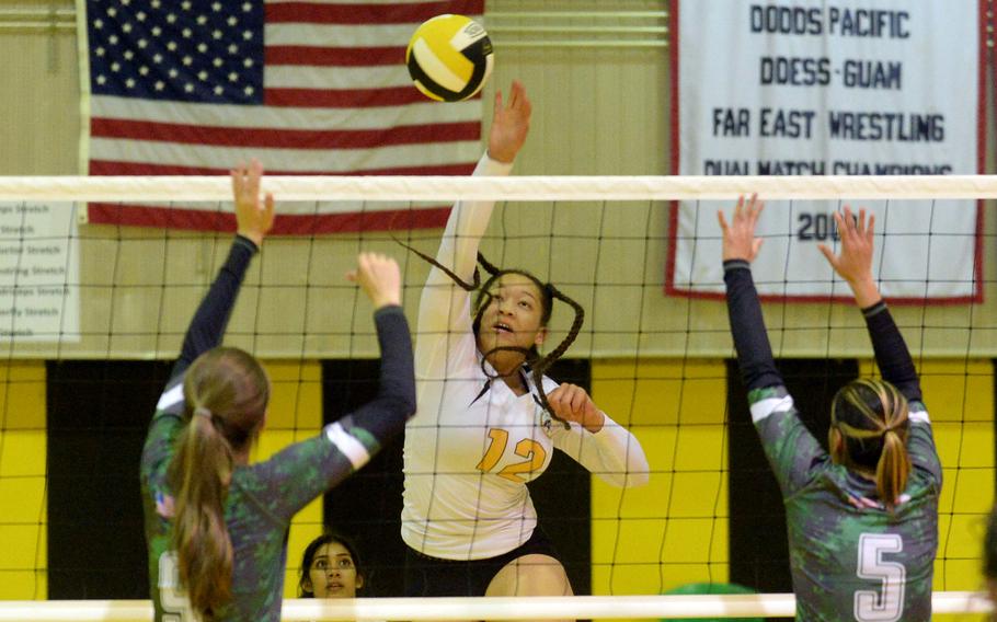 Kadena’s Malana Williams spikes between Kubasaki’s Alice Baron and Alyssa Alvarado during Tuesday’s Okinawa girls volleyball regular-season finale. 