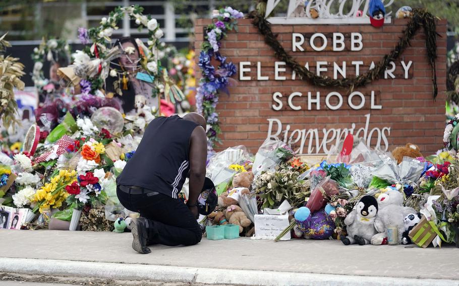 Reggie Daniels pays his respects at a memorial at Robb Elementary School, June 9, 2022, in Uvalde, Texas. A criminal investigation in Texas over the hesitant police response to the Robb Elementary School shooting remains ongoing a year after a gunman killed 19 children and two teachers in Uvalde.