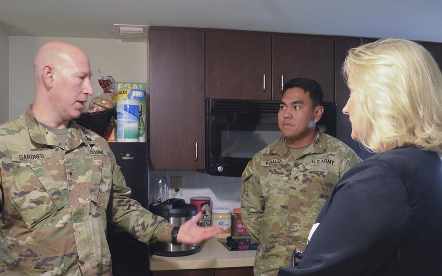 Brig. Gen. David Gardner, commander of Fort Polk, La., and Army Secretary Christine Wormuth speak with Sgt. Edward Peralta in his barracks room at the base April 25, 2023. When asked about dining facilities, Peralta told Wormuth he prefers to cook his own meals so he can have control over his nutrition.