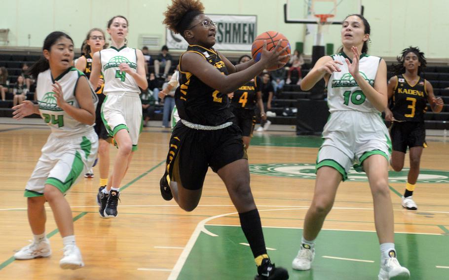 Kadena's Destiny Richardson drives to the basket between Kubasaki's Sawa Cantave and Sophia Grubbs during Thursday's Okinawa girls basketball game. The Panthers won 36-19.