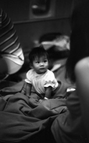 An infant looks up from his blankets.