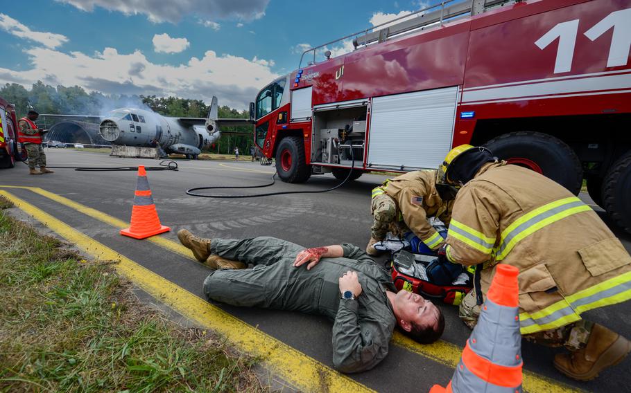 Firefighters assigned to the 86th Civil Engineer Group tend to a victim during a simulated aircraft crash scenario during Operation Varsity, a base-wide exercise at Ramstein Air Base, Germany, July 26, 2022.