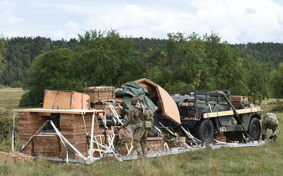 Soldaten der 173. Luftlandedivision, Sept.  August 2022 auf dem Truppenübungsplatz Hohenfels, Deutschland, Demontage und Montage einer M119A3-Haubitze und eines taktischen Fahrzeugs aus einem C-130-Flugzeug. 