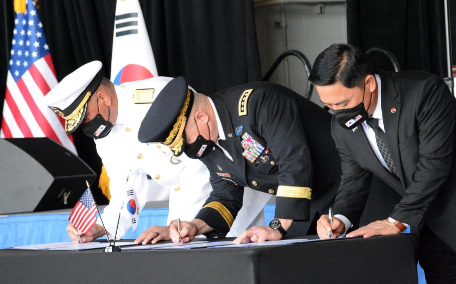 Rear Adm. Darius Banaji, left, deputy director of operations for DPAA; Gen. Paul LaCamera, commander of U.S. Forces Korea and United Nations Command, center; and Heo Wook Goo, director of South Korea’s KIA Recovery and Identification agency sign documents officially transferring service members’ remains at Joint Base Pearl Harbor-Hickam, Hawaii, Wednesday, Sept. 22, 2021. 