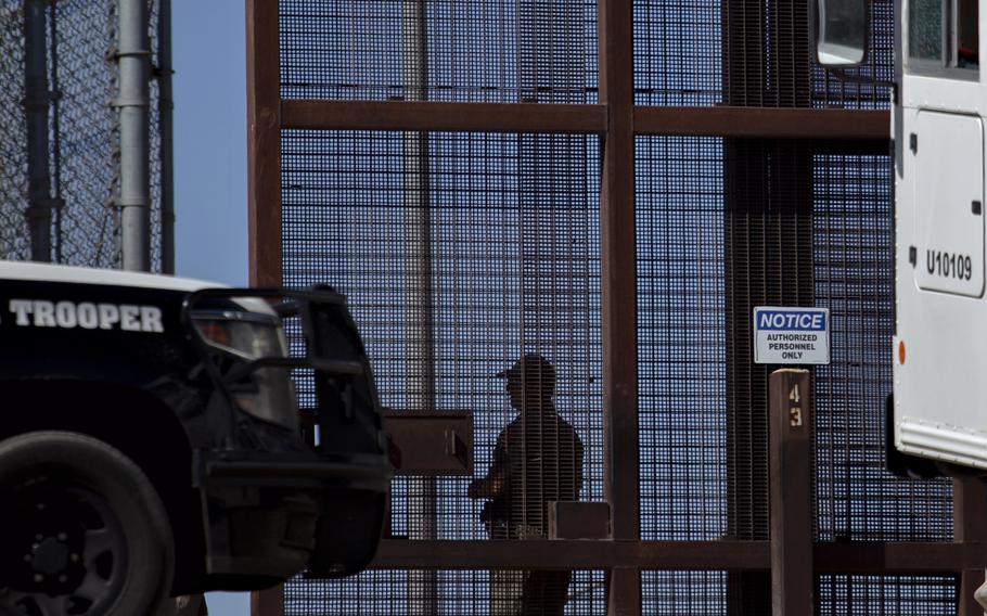 U.S. Customs and Border Protection agents coordinate the movement of migrants after they cross through the border wall from Ciudad Juárez, Mexico, to be sent for processing in El Paso on May 11, 2023. 