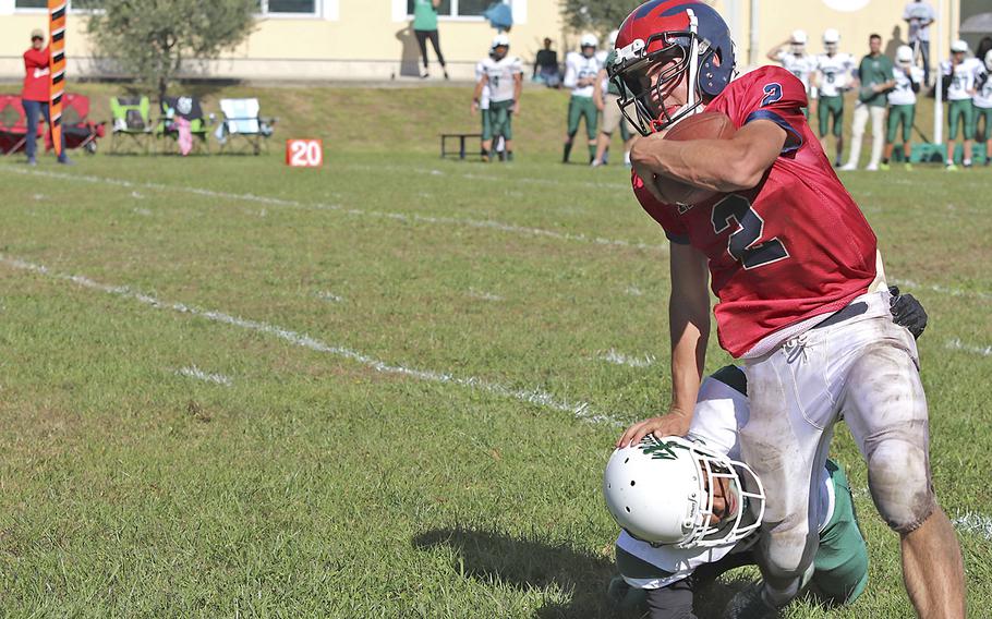 Aviano’s Eric North attempts to run past a Naples Wildcat defender during Saturday’s football game held at Aviano. The Wildcats won the game decisively by the score of 40-0.