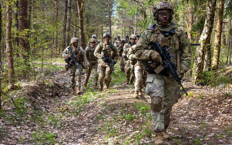U.S. soldiers assigned to Eagle Troop, 2nd Squadron, 2nd Cavalry Regiment, walk to the range during exercise Defender 24 at Bemowo Piskie Training Ground, Poland, April 16, 2024. Army leaders recently acknowledged potential benefits and challenges of permanently basing more soldiers in Poland, noting the strain on troops from increased deployments and the high costs associated with overseas military infrastructure.