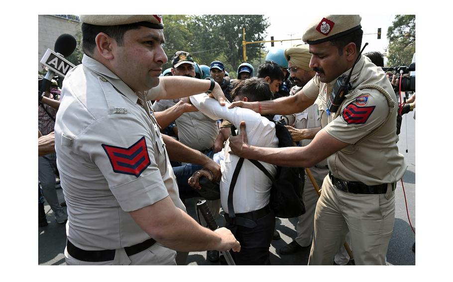 Police officers remove a demonstrator blocking traffic during a protest against the arrest of Delhi Chief Minister Arvind Kejriwal in Delhi, India, on March 22, 2024.