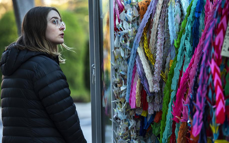 Kate Chapman, visiting from Australia, admires the origami cranes displayed at Peace Memorial Park in Hiroshima, Japan, Feb. 28, 2023.