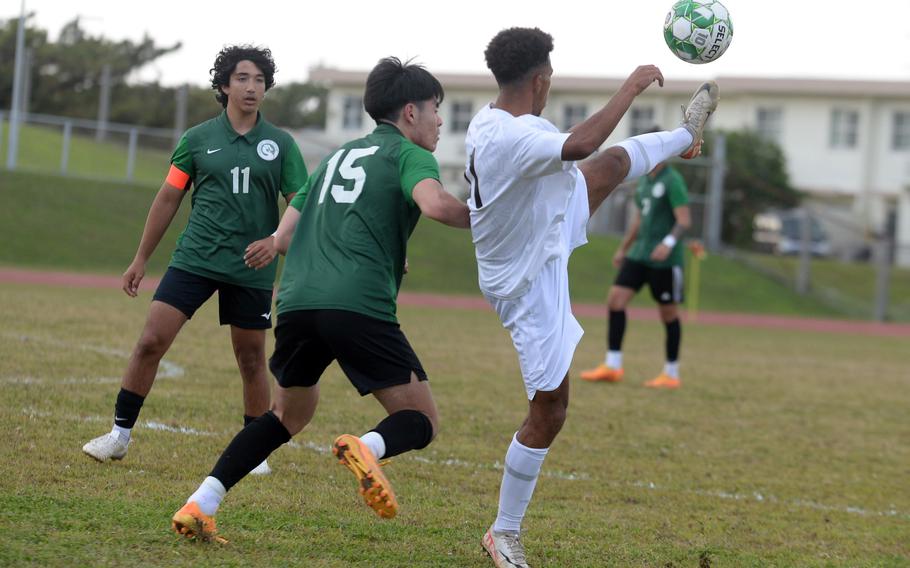 Kadena’s Yoshua Whipp tries to settle the ball in front of Kubasaki’s Cody Wong and Jaden Oshana during Wednesday’s DODEA-Okinawa boys soccer match. The Panthers beat the Dragons 5-0.