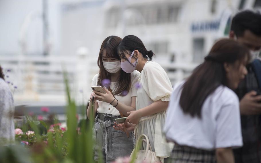 People wear masks earlier this spring while strolling around Yamashita Pier in Yokohama, Japan. 