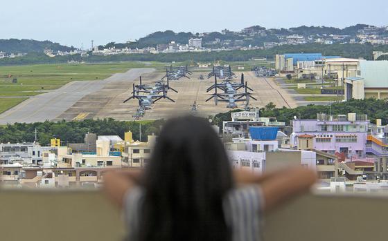 A child looks out at aircraft, including MV-22B Ospreys, at Marine Corps Air Station Futenma, Okinawa, April 19, 2019.