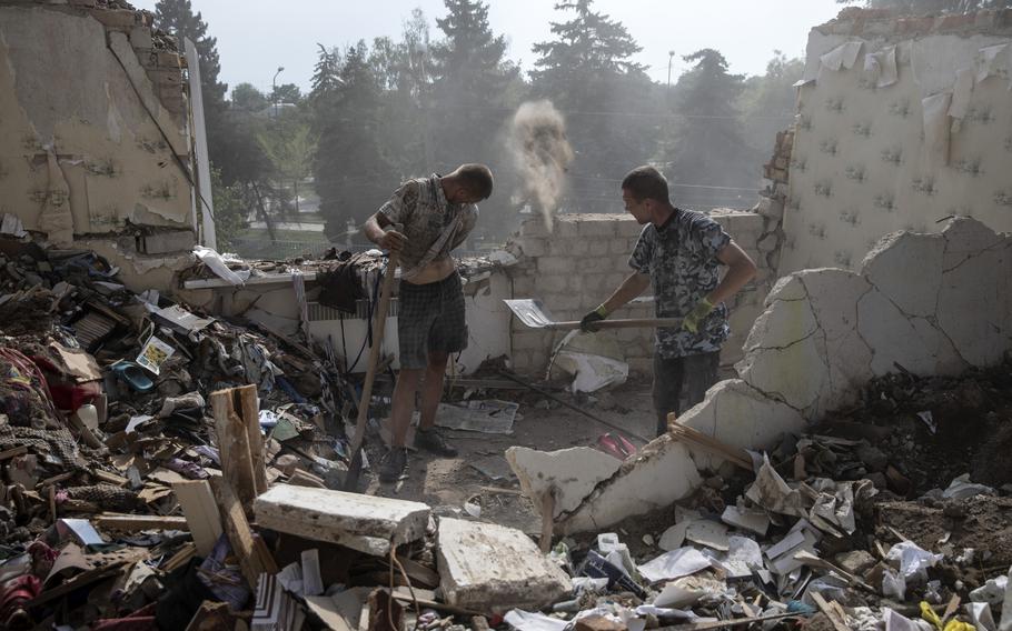 Andre Kovalenko and Victor, who gave only his first name, work to recover belongings from a badly damaged apartment after a Russian attack in Nikopol, Ukraine, on Aug. 12, 2022. 