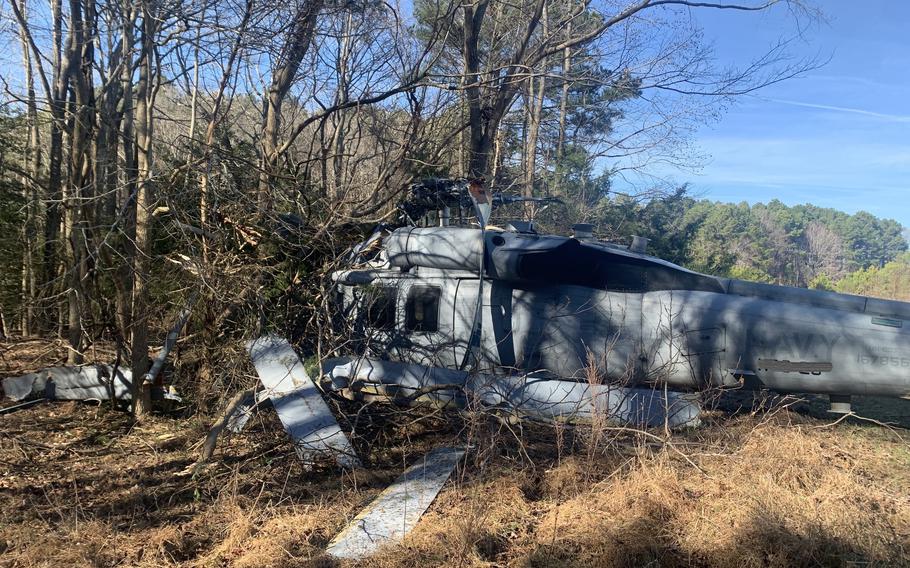 The wreckage of a Navy helicopter after making an emergency landing in Isle of Wight County, Va.  The helicopter hit several trees as it made an emergency landing, leaving a passenger with minor injuries, Virginia State Police said.   