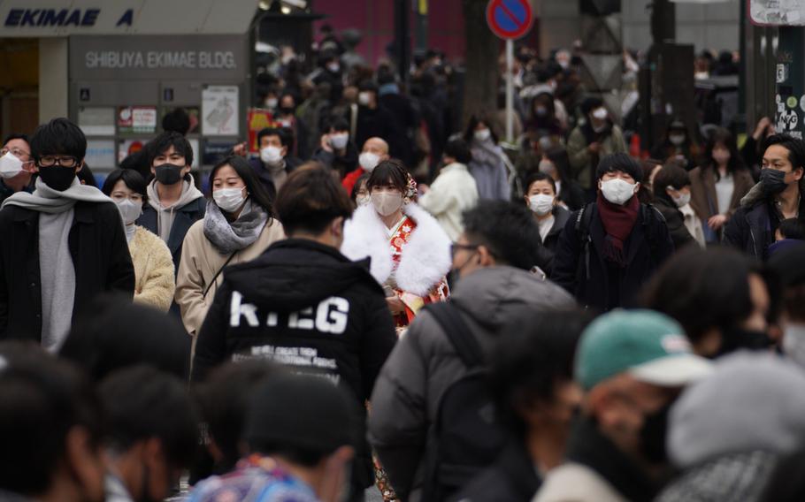 Crowds of people move through the Shibuya district of central Tokyo on Jan. 10, 2022. 