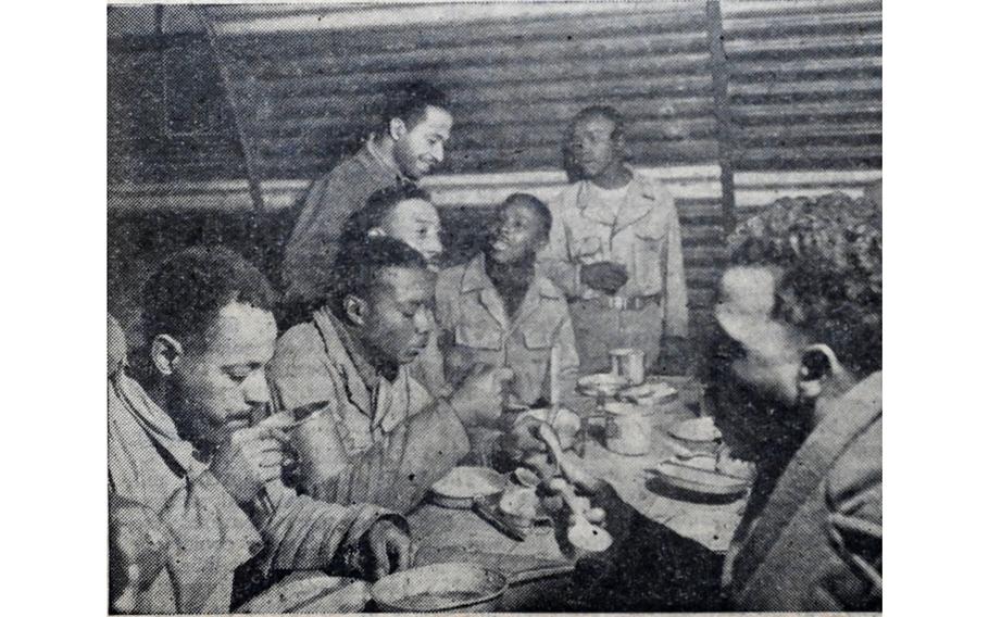 “A typical chow table at a battery mess hall,” read the original caption on this image, first published in the Northern Ireland edition of Stars and Stripes Feb. 10, 1944. A group of soldiers belonging to an all-Black anti-aircraft battalion stationed on the British Isles eat and socialize in their mess hall.