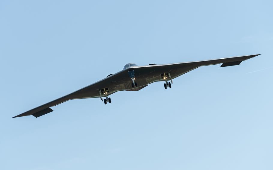 A B-2 bomber flies through open air with blue sky behind it.