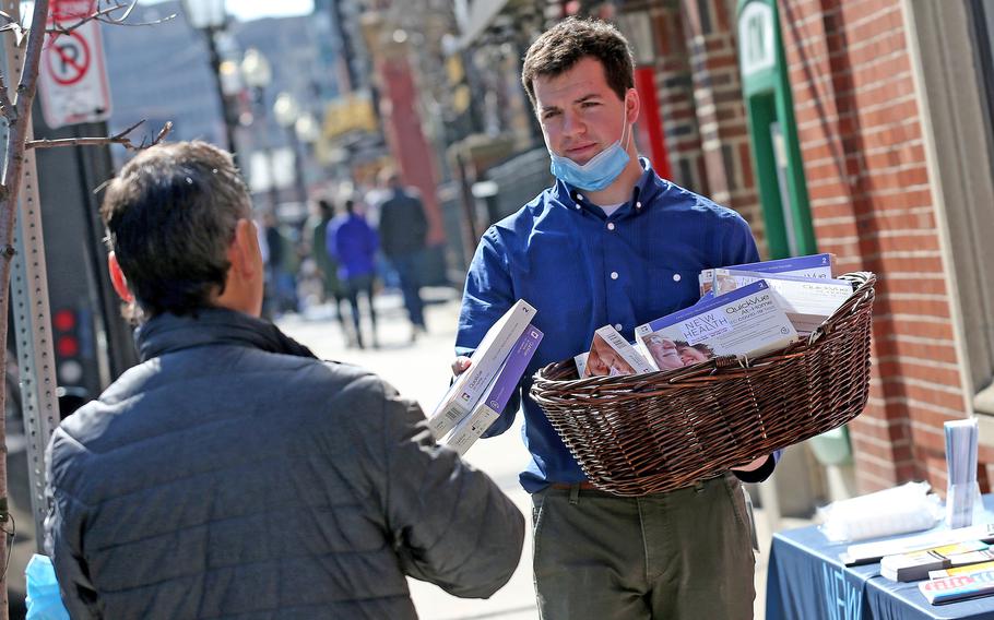 Danny Coakley of North End Waterfront Health gives out free COVID-19 test kits outside of NEW Health's North End site on March 11, 2022, in Boston. 