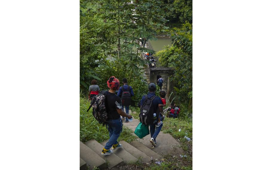 A group of Haitian migrants following smugglers’ instructions cross the Cahoacan river. Many carry their young children across the rickety bridge in addition to their belongings.