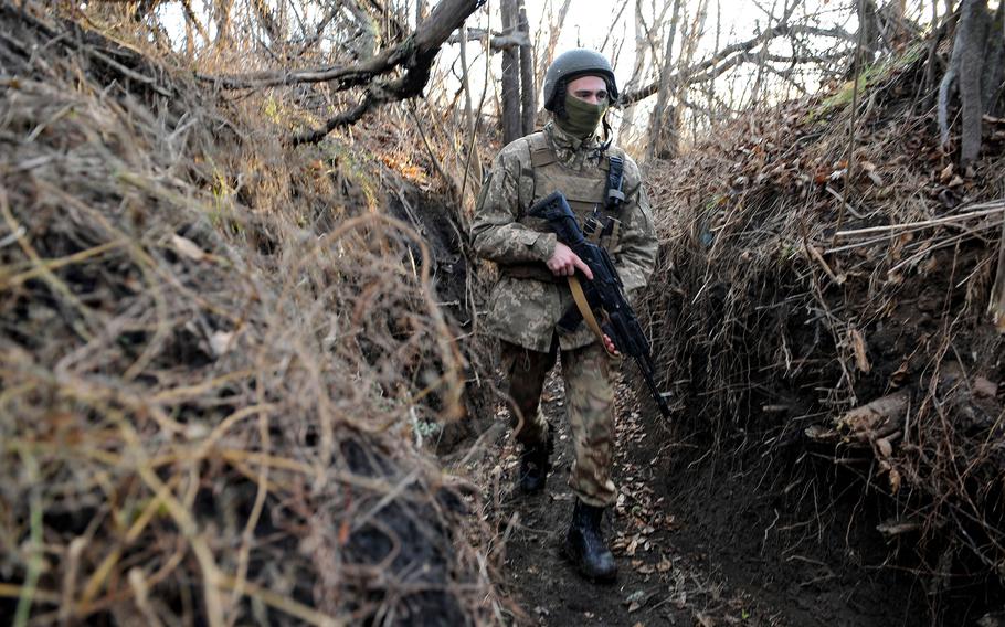A Ukrainian service member walks along a trench on the front line with Russia-backed separatists near the village of Talakivka, Donetsk region, on Wednesday, Nov. 24, 2021. 