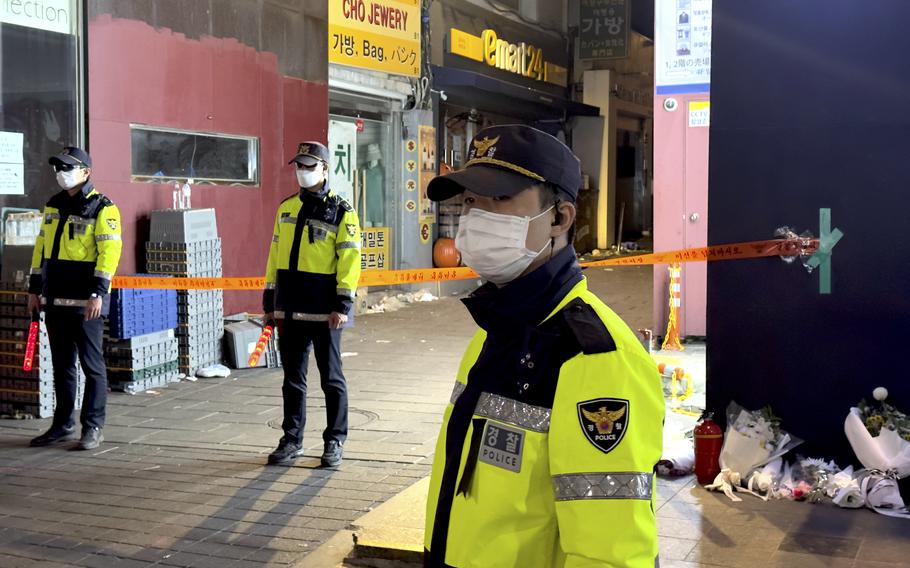 South Korean police guard the entrance to an alleyway where some of the 159 victims were killed after a crowd of people were crushed during Halloween festivities in Itaewon, South Korea, Oct. 29, 2022 .