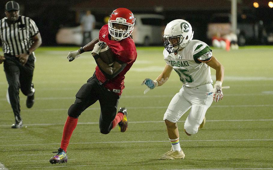 Nile C. Kinnick's Tre Bennett tries to outrun Kubasaki's Roman Leal.