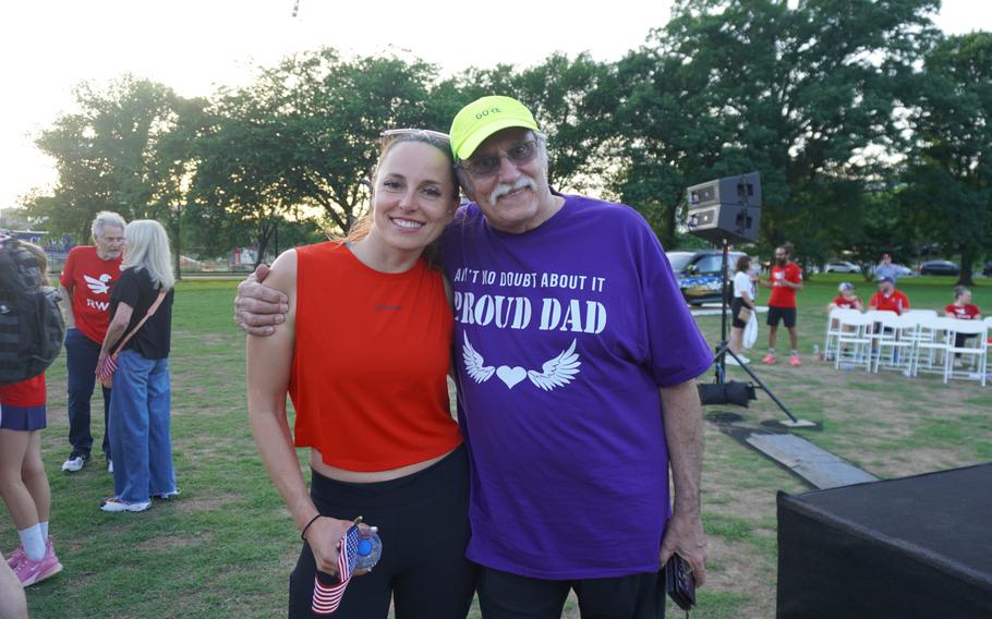 A woman and her father pose for a photo