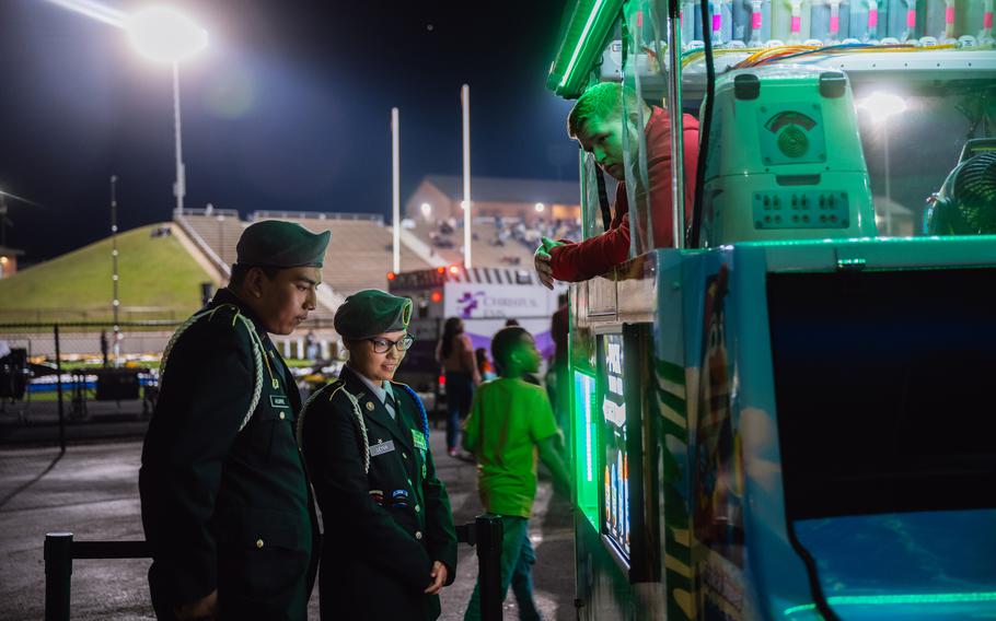 Israel Aguirre, 17, and Joseline Leyva get snow cones during the football game. 