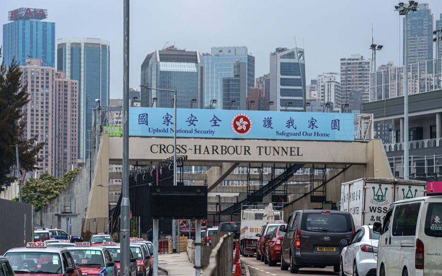 Vehicles travel past a government-sponsored advertisement promoting the national security law atop an entrance to the Cross Harbour Tunnel in Hong Kong on April 14, 2021. MUST CREDIT: Bloomberg photo by Lam Yik.