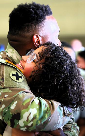 A soldier embraces his sister