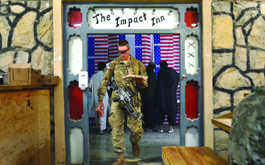 Pfc. Nathan Jackson carries a plate of food in "The Impact Inn," the nickname for the dining facility at Combat Outpost Sabari, Khost province.