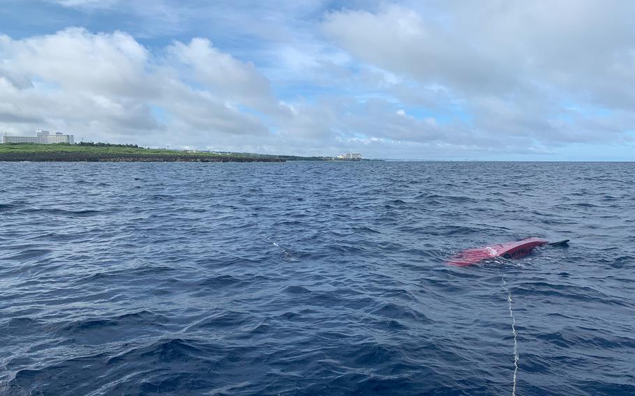 A kayak attached to a rope is flipped over half a mile off the coast of Cape Zanpa, Okinawa, June 13, 2021. It had been used by four Japanese men who found themselves stranded off the coast before being rescued by an airman and a civilian from Kadena Air Base. 