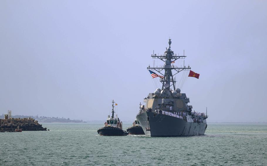 The Oscar Austin sails into port, with accompanying boats beside it.