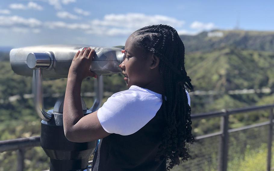 Avery Jenkins, 9, of Atlanta peers through a scope at Griffith Park Observatory during her family’s visit to Los Angeles. Her parents are thrilled that a Black American, Pomona native Victor Glover Jr., will be part of NASA’s Artemis II lunar mission.