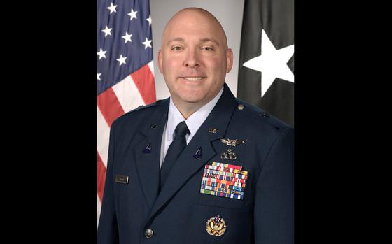 A man in formal military attire smiling for a portrait.